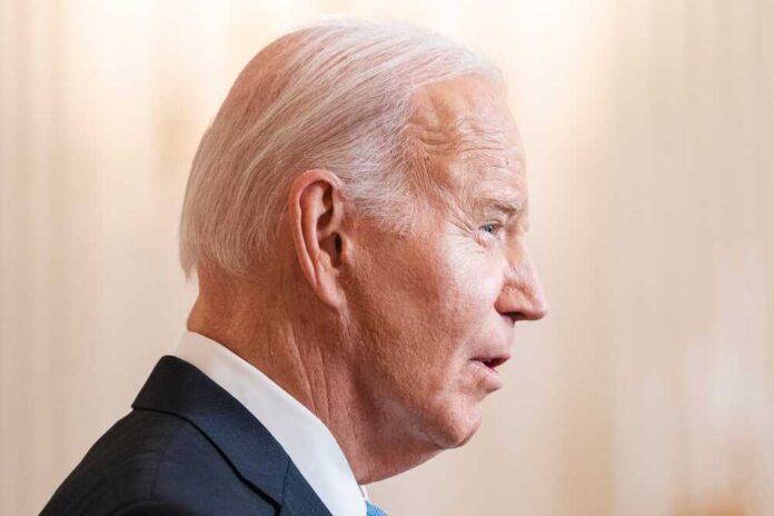 Joe Biden in a suit speaking, facing right.