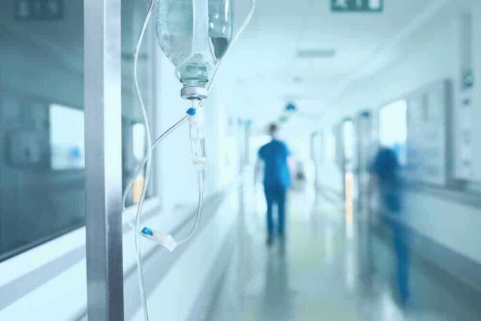 shutterstock_528854752-1.jpg featured image Hospital corridor with IV drip and healthcare worker.