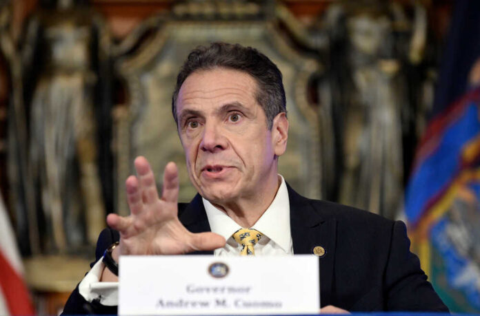 shutterstock_1697635930.jpg featured image Andrew Cuomo speaking at a press conference, wearing a suit.