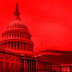 United States Capitol building under red-tinted sky.