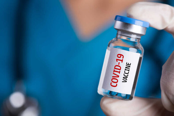 shutterstock_1692105757.jpg featured image Person holding a vial labeled COVID-19 Vaccine.