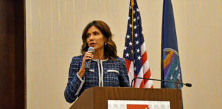 Kristi Noem speaking at KS GOP event podium.