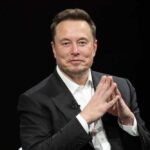Elon Musk in a suit talking.