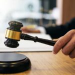 Judge SLAMS Brakes on Trump’s Health Agency Overhaul Gavel in judge's hand about to strike.