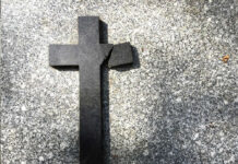 Broken black cross on a gray surface