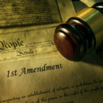 Judge’s Ruling: $20K for “Illegal Aliens” Comment Gavel and Constitution with 1st Amendment