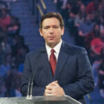 Ron DeSantis in a suit speaking