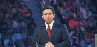 Ron DeSantis in a suit speaking