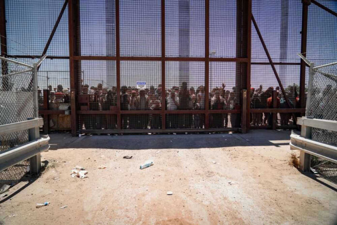 People standing behind the border wall