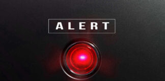 Red alert light against black background text ALERT