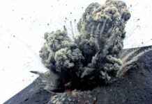 Volcano erupting with smoke and ash plumes rising