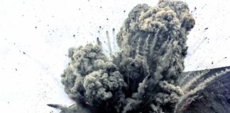 Volcano erupting with smoke and ash plumes rising