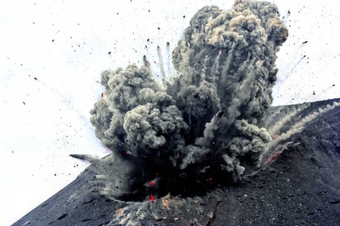 Volcano erupting with smoke and ash plumes rising