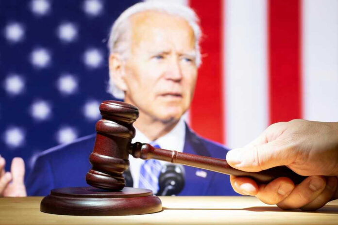 shutterstock_2400282329.jpg Joe Biden with a hand holding a gavel