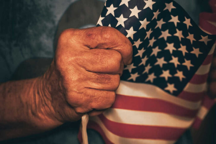 Hand holding small American flag tightly