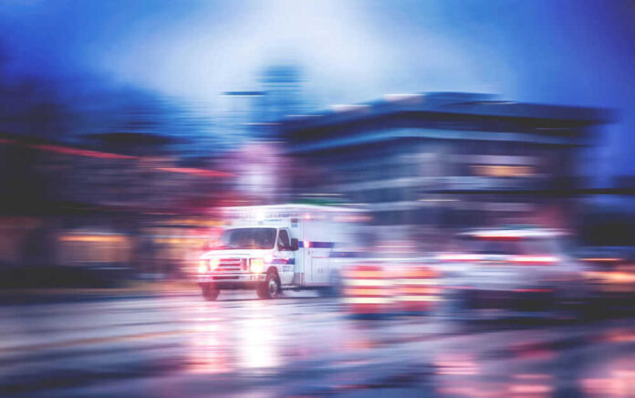 Ambulance speeding through city street at night