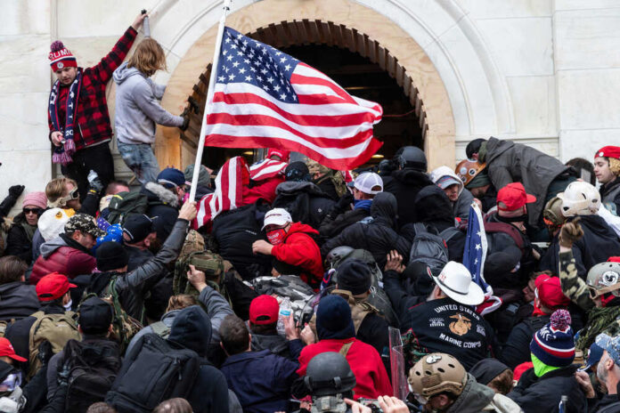 Crowd with American flags storming a building entrance