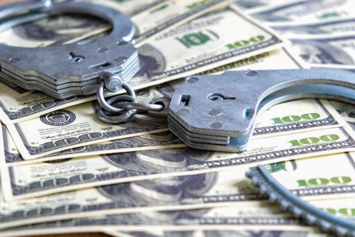Handcuffs on a pile of one hundred dollar bills