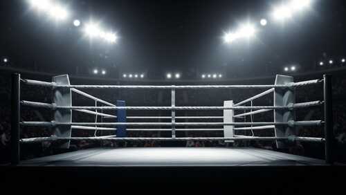 An empty boxing ring illuminated by bright lights in a sports arena