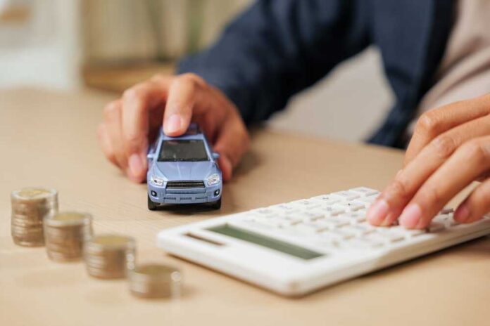 Person calculating expenses with a toy car and coins on the table