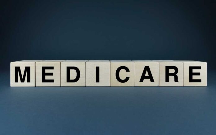 Wooden blocks spelling out MEDICARE on a dark background