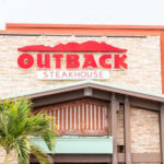 Exterior view of an Outback Steakhouse restaurant with a prominent sign