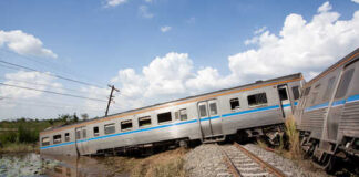 Derailed train car leaning off the tracks near a body of water