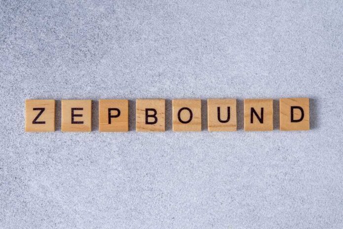 Wooden letter tiles spelling the word 'ZEPBOUND' on a gray surface