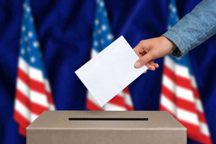 Hand casting a vote into a ballot box.