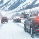 Cars driving on a snowy road in winter conditions