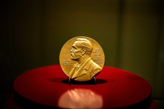 A gold Nobel Prize medal displayed on a red pedestal