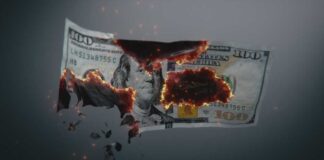 A hundred dollar bill appearing to burn and disintegrate