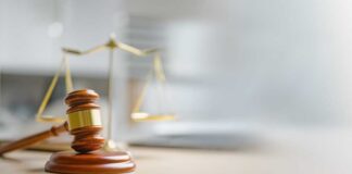 A wooden gavel and scales of justice on a desk