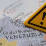 A close-up of a map of Venezuela with a yellow warning sign