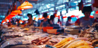 A bustling seafood market with various types of fish and seafood displayed