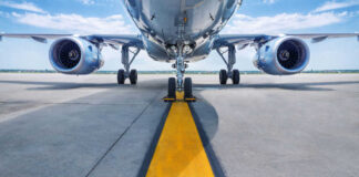 Airplane on runway with visible landing gear engines
