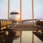 Airplane viewed from an empty airport waiting area.