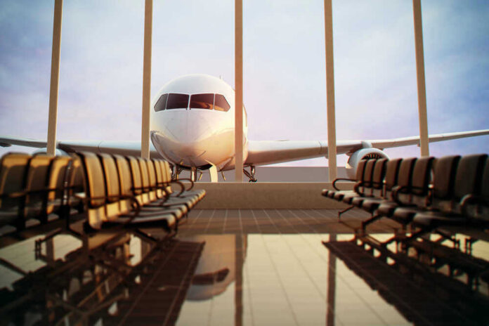 shutterstock_124713472.jpg Airplane viewed from an empty airport waiting area.