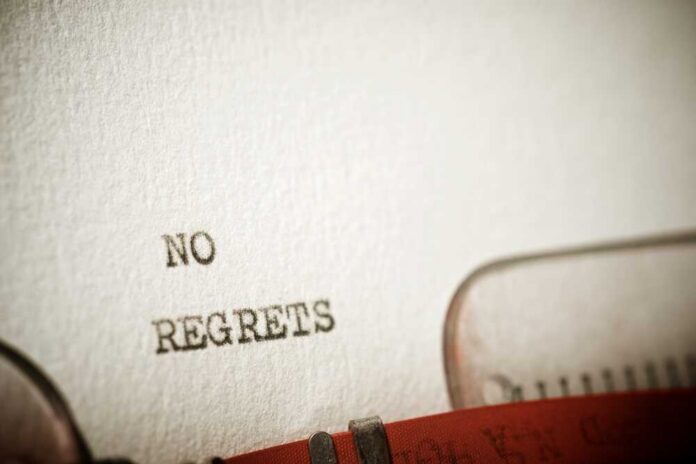 Close-up of a typewriter with the words 'NO REGRETS' typed on paper