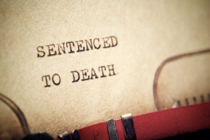 Close-up of a typewritten document stating 'SENTENCED TO DEATH'