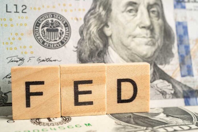 shutterstock_2288692811.jpg Wooden blocks spelling 'FED' in front of a hundred dollar bill