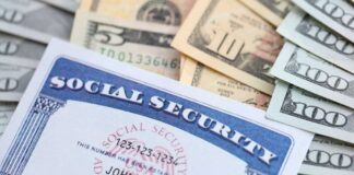 A social security card placed on top of various denominations of U.S. currency