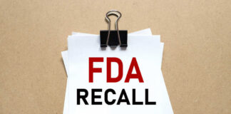 A notice labeled 'FDA RECALL' clipped to white papers on a brown background