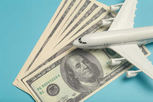 A model airplane placed on top of dollar bills