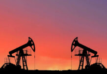 Oil pumps silhouetted against colorful sky background