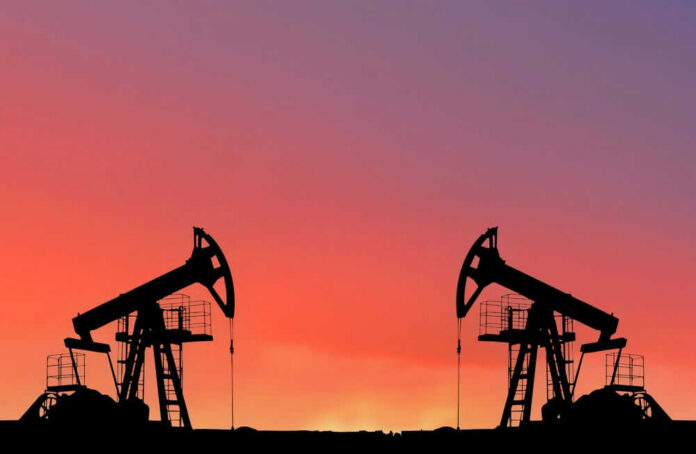 Oil pumps silhouetted against colorful sky background