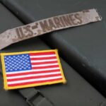 Military patches including a US Marines insignia and an American flag on a green surface