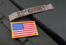 Military patches including a US Marines insignia and an American flag on a green surface