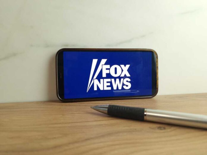 Smartphone displaying the Fox News logo on a wooden surface