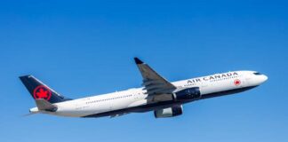 Air Canada airplane flying against a clear blue sky